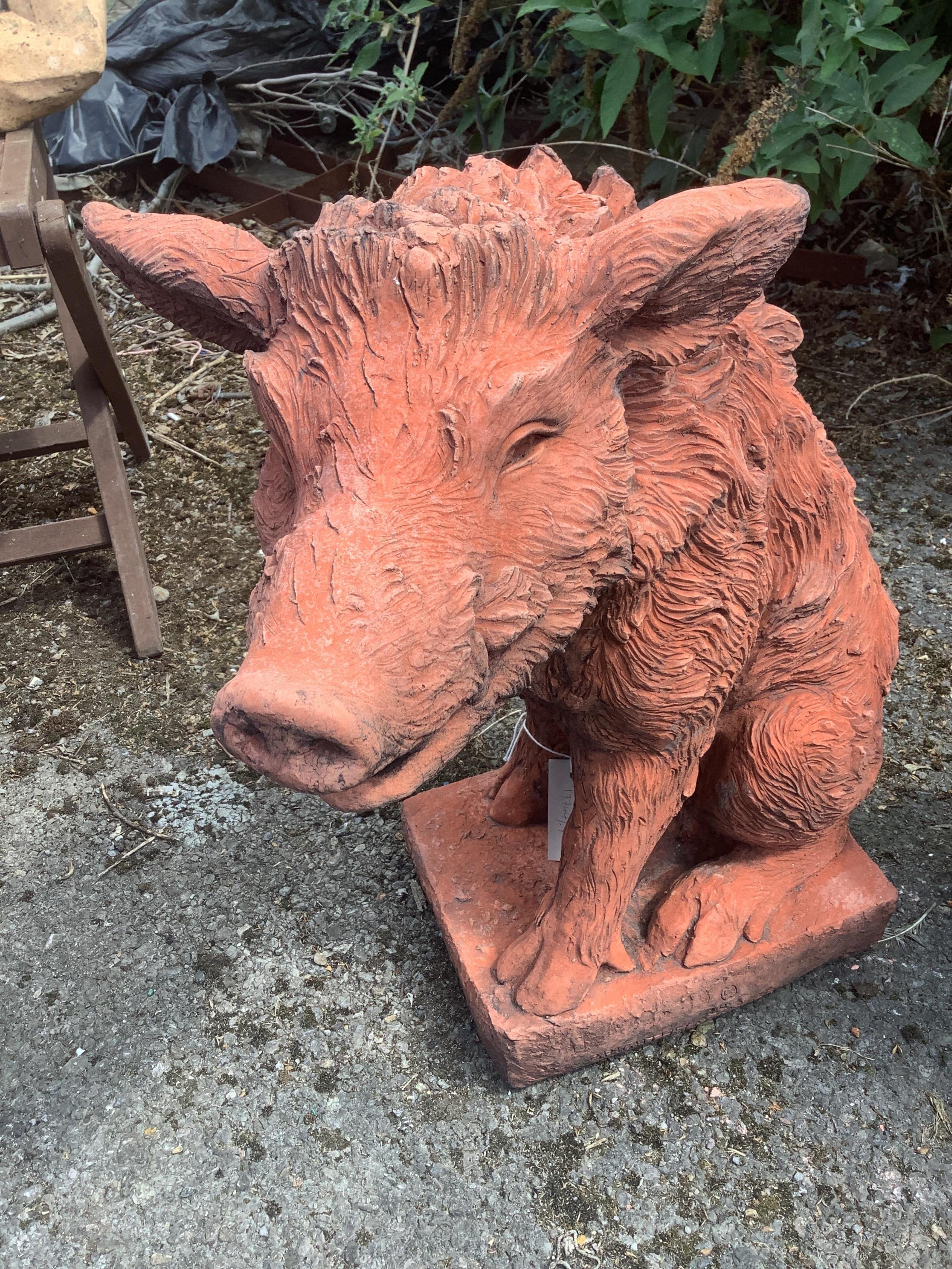 A pair of terracotta seated wild boar garden ornaments, height 55cm